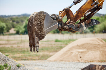 Steel Mini Bucket on the arm of an Excavator digging a trench