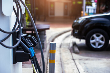 EV charging station with blurry an electric car. Power supply for electric car charging. Socket for electrical car battery charger. EV car charging station in parking. Nature energy, Green eco concept