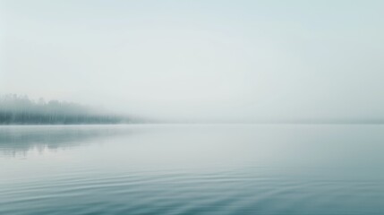 Fototapeta premium A serene lake overlaid with a thin layer of mist, the water surface barely visible, creating a peaceful and ethereal morning scene