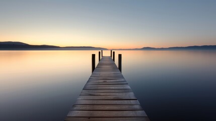 Obraz premium A serene lakeside dock made from aged timber, with calm waters and a beautiful sunset in the background