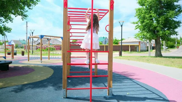 Child playing on outdoor playground. Kids play on school or kindergarten yard. Active kid on colorful monkey bars. Healthy summer activity for children. Little girl climbing.