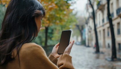 Woman Using Smartphone on City Street in Autumn