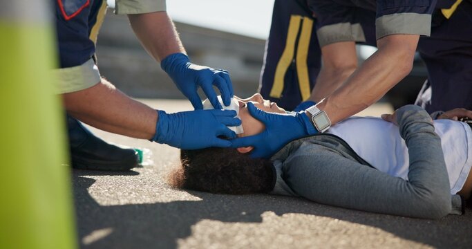 Paramedic, accident and hands on head injury on road in car crash emergency with healthcare people. EMS, wrapping bandage or first responder with victim or rescue in street for transport to hospital