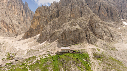 aerial drone view of the Langkofelhütte mountain hut during summer with impressive dolomites in...