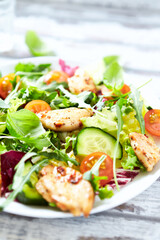 Salad with Chicken Breast, Cherry Tomatoes, Cucumber, Rocket and fresh Basil. Bright wooden background. Close up.	