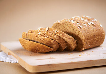Homemade wholemeal oats bread cut into slices lies on cutting board