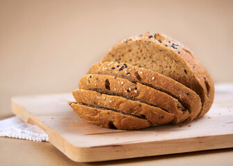Homemade sesame wholemeal bread cut into slices lies on cutting board
