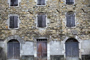 Old building with wooden door, stone wall and wooden shutters - Rochecolombe - Ardeche - France