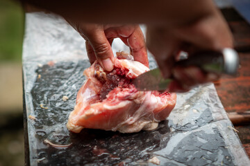 Someone is cutting chicken to cook
