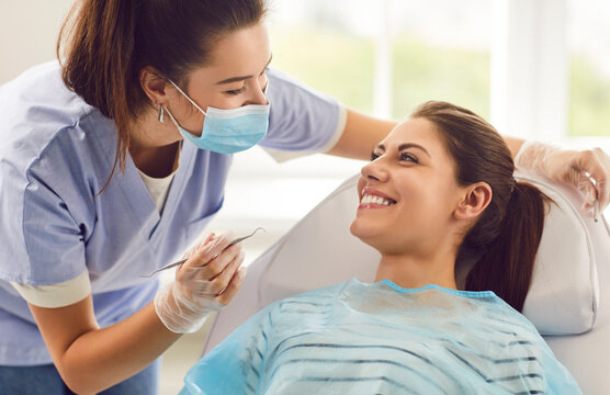 Doctor dentist or nurse conducting a medical checkup of a patient in a clinic, using a dental instrument. Oral care examination improving dental health, providing quality dentistry service.