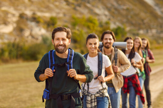 Portrait of a group of tourists against the mountain landscape. This team of friends demonstrates the essence of vacation, teamwork in travel, and friendship as the hikers share the joy of community.