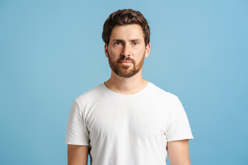 Obraz premium Young bearded man wearing casual posing isolated on blue, looking at camera