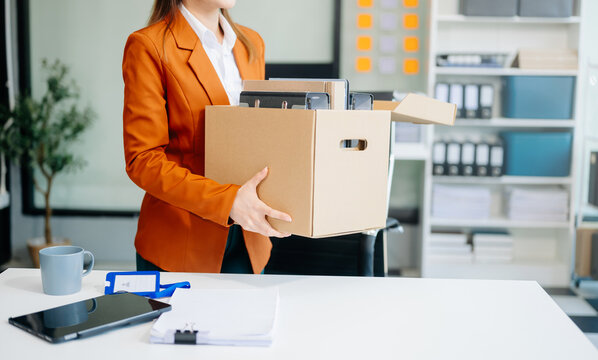 young beautiful Asian woman office worker celebrating her resignation, carrying her personal stuff. leaving job, changing or company
