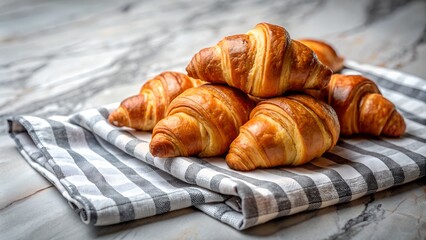 Freshly baked croissants resting on a striped cloth