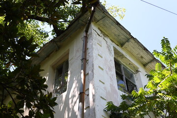 A worn-out building with a cracked window in its center, perfect for use as a background or to...