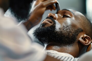 Close-up of barber trimming beard of Black man