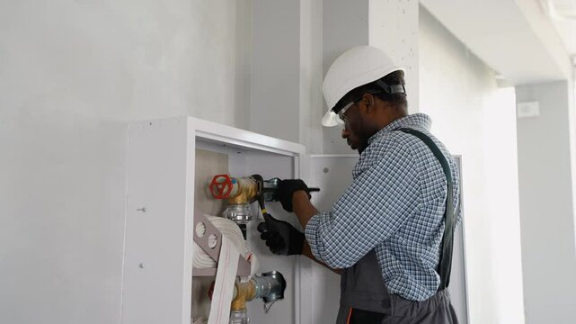 Plumber using wrench while installing fire hydrant in office