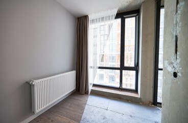 Comparison of apartment flat before and after restoration or refurbishment. Photo collage of old room with large windows and new renovated room with heating radiator, parquet floor and white walls.