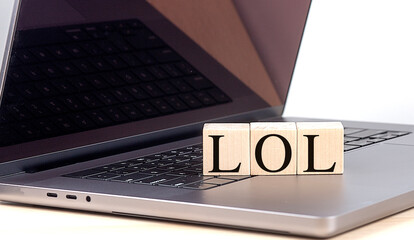 LOL word on wooden block on a laptop , business concept