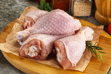 Raw uncooked chicken drumsticks over board