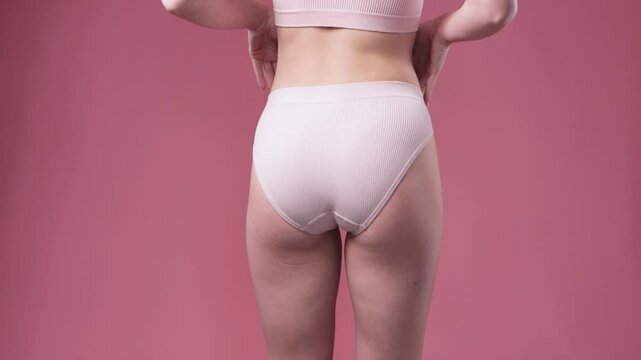 Girl pulls the skin on the abdomen and on the hips showing the body fat. Treatment and disposal of excess weight, the deposition of subcutaneous fat.