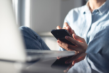 Young casual business woman sitting on the floor using stylus pen and digital tablet, working on...