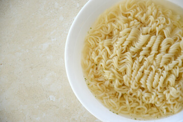 Bowl of instant cooking noodles on white marble table. Traditional asian food