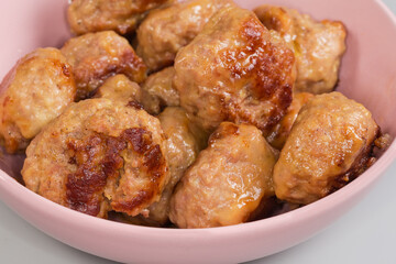 Prepared meat patties in pink bowl, fragment close-up