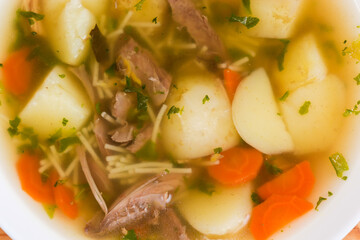 Chicken vermicelli soup in bowl, fragment top view