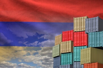 Armenia flag and big stack of shipping cargo containers in docks with sky background close up
