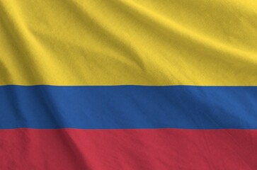 Colombia flag depicted on folded wavy fabric of old cloth close up