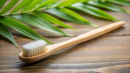 Bamboo toothbrush lying on wooden surface with tropical leaf