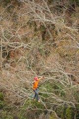 A tightrope walker walks along a rope stretched over a conyon.