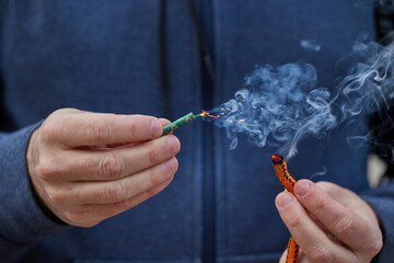 Close up of man hand lighting up a firecrackers with wick