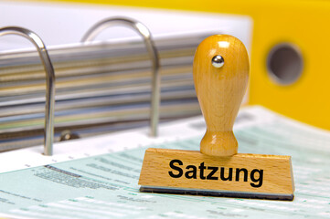 Ein Holzstempel ist beschriftet mit dem Aufdruck: Satzung