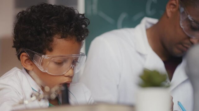 African American boy and father playing scientists, conducting lab experiments