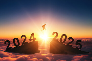 Happy new year 2025, Silhouette Man jumping from 2024 cliff to 2025 cliff on sky background. Сoncept of moving from year to year. New Year's concept.