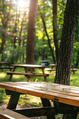 Fototapeta premium Empty wooden table with a barbecue on a sunny summer day in the park