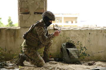 Military mission. Soldier in uniform with drone controller inside abandoned building, space for text © New Africa