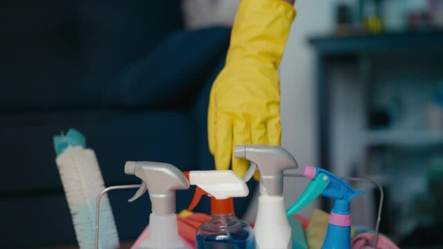 Cleaning service worker places a bucket with supplies and detergents on floor