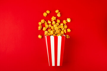 Bucket of sweet caramel popcorn on a wooden background. Salted caramel popcorn. Caramel sauce. Close up. Topping. Place for text. Copy space