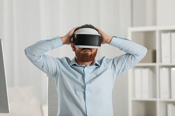 Man using virtual reality headset at workplace in office
