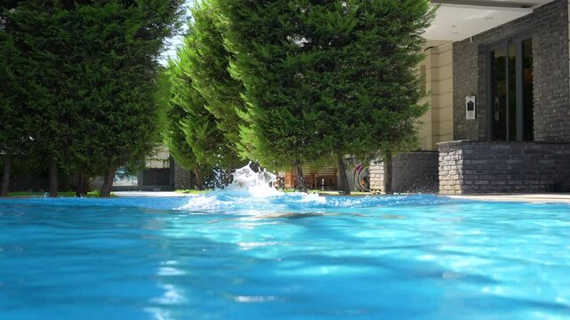 Young woman jumping in the pool.