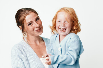Happy family moments mother and daughter smiling together in front of white background