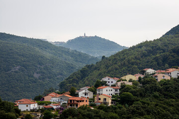 Obraz premium View of the village of Rabac on the Istrian coast of Croatia with the mountains and the town of Labin in the background