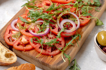 Tomatoes salad Organic tomatoes carpaccio with pesto sauce and arugula, an on-trend summer healthy eating salad