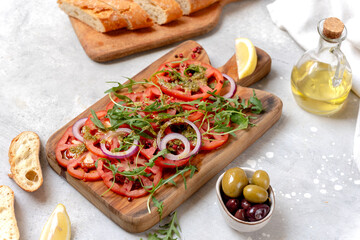 Tomatoes salad Organic tomatoes carpaccio with pesto sauce and arugula, an on-trend summer healthy eating salad
