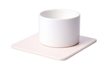 A White Ceramic Cup Resting on a Soft Pink Square Coaster on a Clear PNG or White Background.