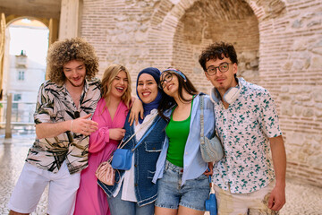 A diverse group of tourists, dressed in summer attire, strolls through the tourist city with wide smiles, enjoying their sightseeing adventure