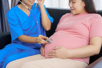 Obraz premium Pregnant mothers meet the nurse at the clinic as scheduled, reviewing their medical history and discussing symptoms. Sitting on the sofa, they report headaches, nausea, and back pain to the nurse.
